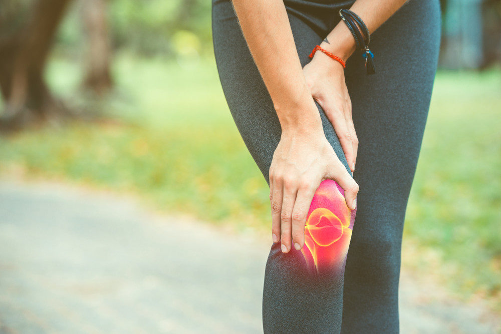 Woman holding inflamed knee