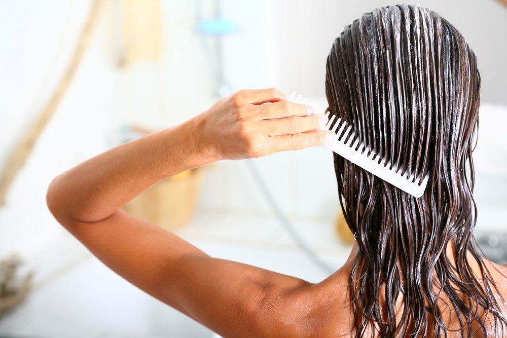 Woman putting conditioner in hair
