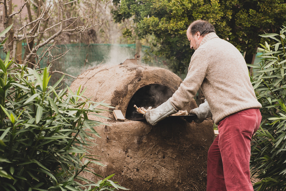 Man cooking with earth oven